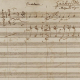 Detail aus dem Autograph der Zauberflöte, Signatur: Mus. ms. autogr. Mozart, W. A. 620. Seite 1: Mit Schriftzug von Georg Nikolaus Nissen: „Zauberflöte | Mozarts eigne Handschrift“
