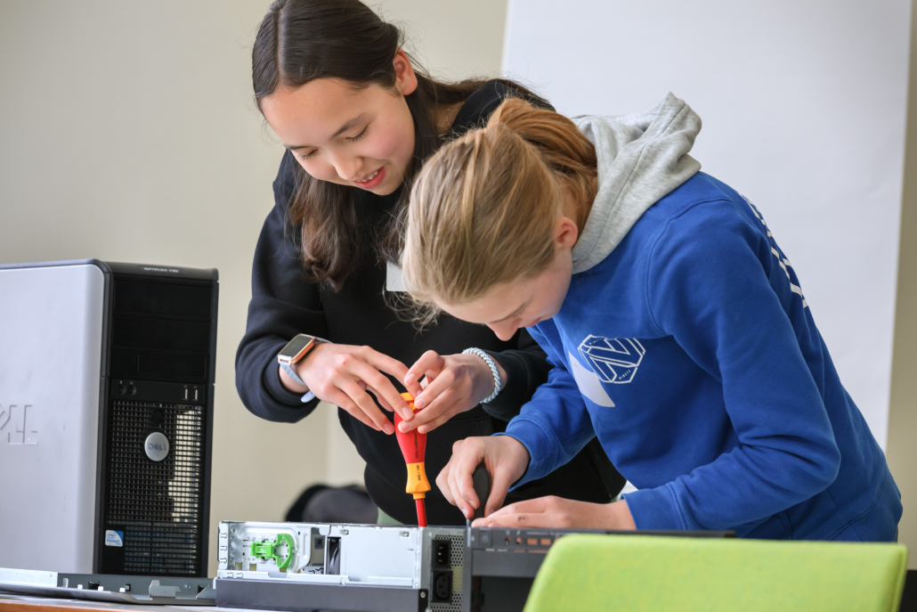Zwei Mädchen bauen einen Rechner auseinander