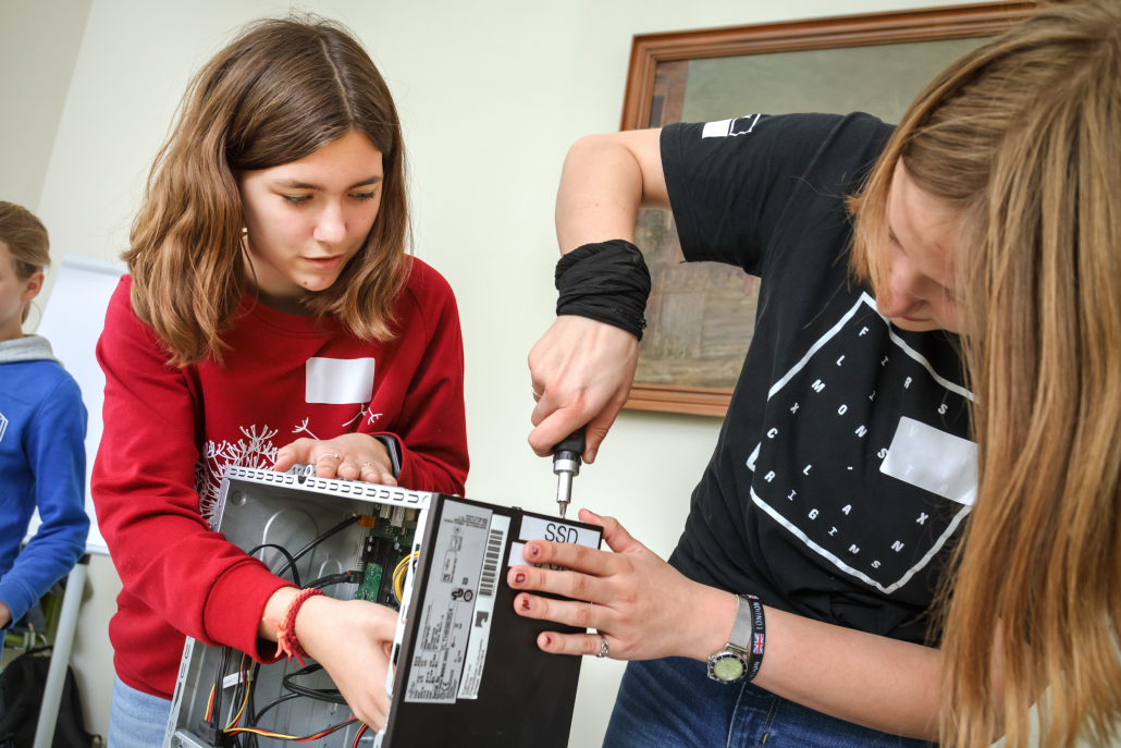 Zwei Mädchen bauen einen Rechner auseinander