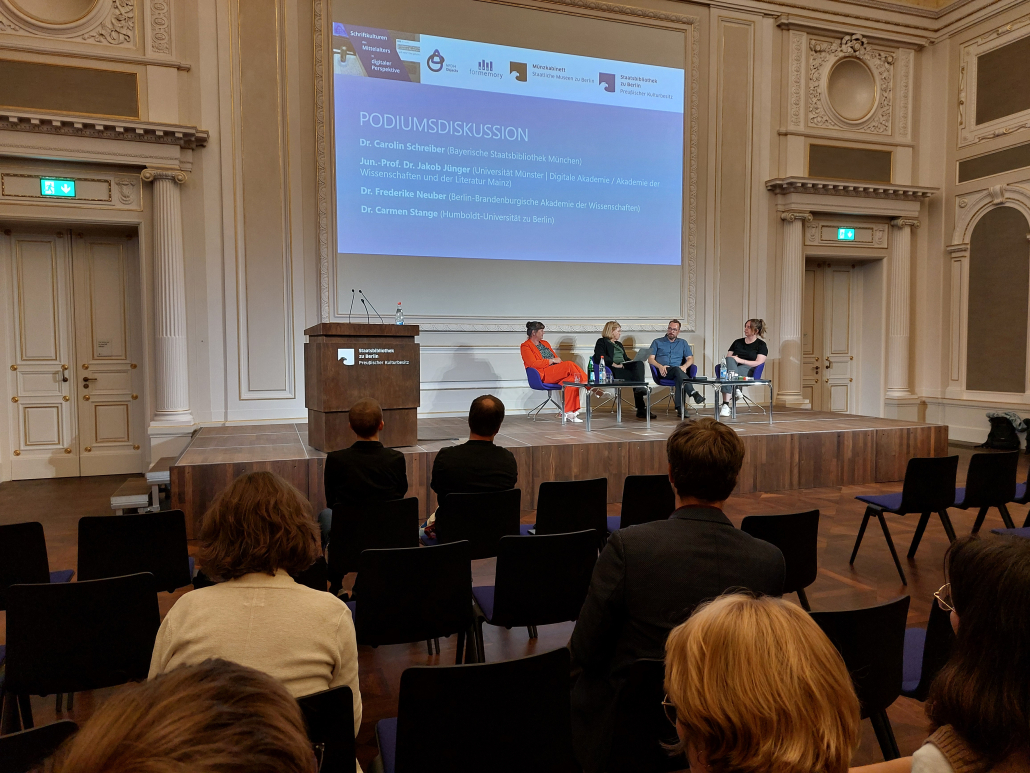 Personen diskutieren auf einem Podium