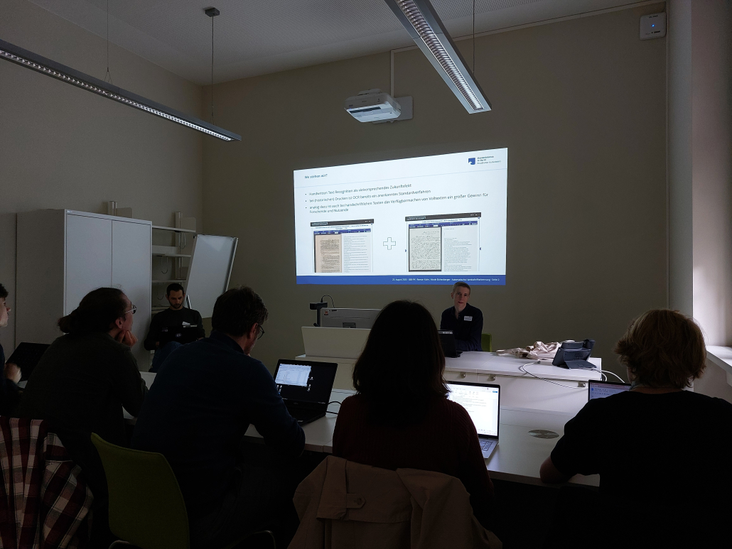 Eine Gruppe betrachtet eine PPT-Präsentation.