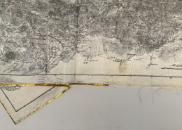 Detailansicht des zerstörten Goldrandes und des ausfransenden Stoffes, Abbildung einer Küstenregion