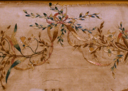 Detailaufnahme der dekorativen Elemente: obere Randverzierung aus gestickten Blättern, Blüten und Schleifenbändern