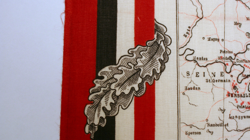 Detailaufnahme des rot-schwarzen Randes, verziert mit Eichenblättern